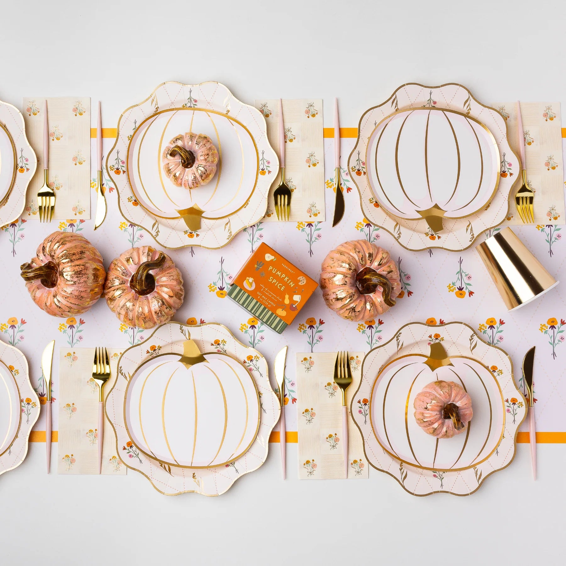 Long tablescape showing the Cozy Fall Floral table runner layered under pumpkin plates and gold flatware.