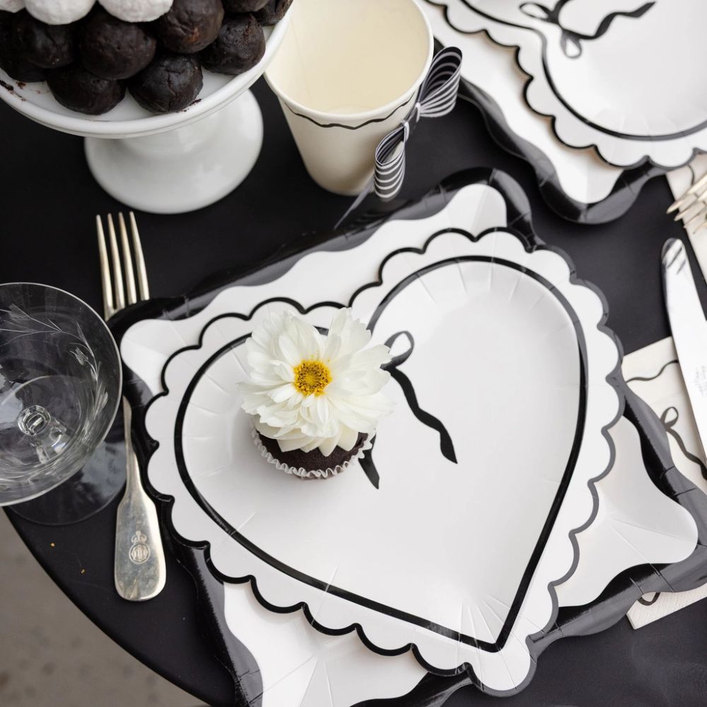 Cream and black scalloped plates styled on a monochrome Valentine’s table setting.