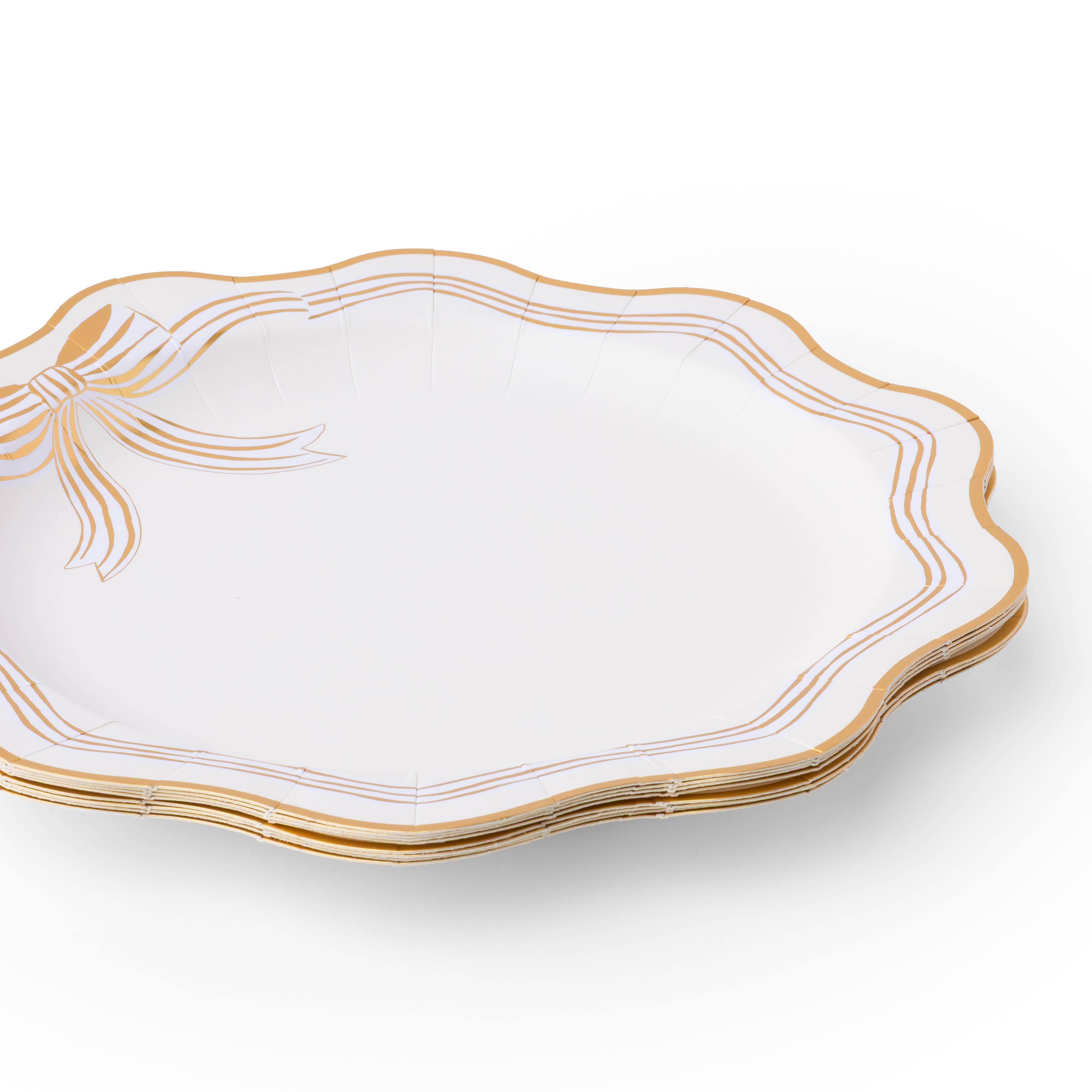 Stack of cream and gold bow dinner plates with gold foil detail