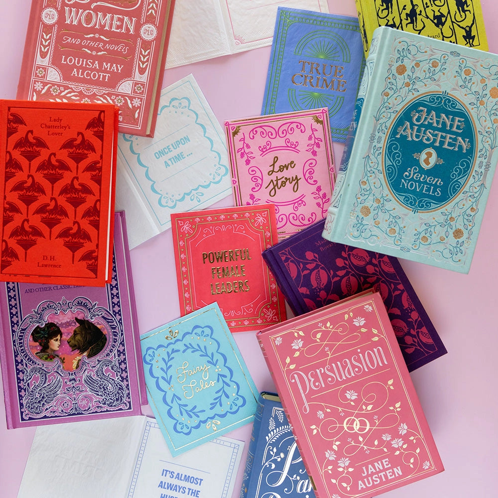 Assortment of colorful literary-themed cocktail napkins displayed with vintage-style hardcover books.