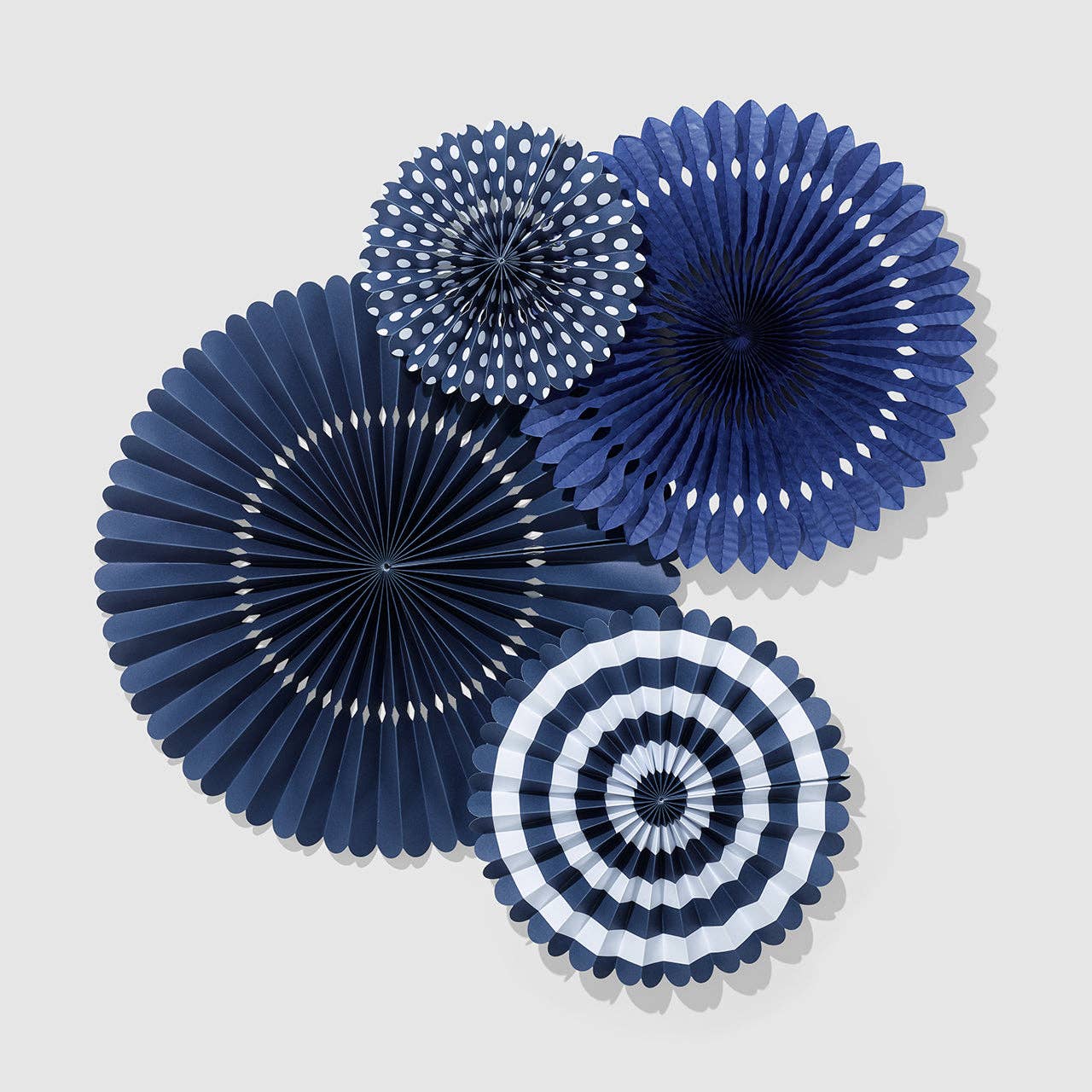Set of four midnight navy party fans in assorted sizes and patterns including white stripes and polka dots.