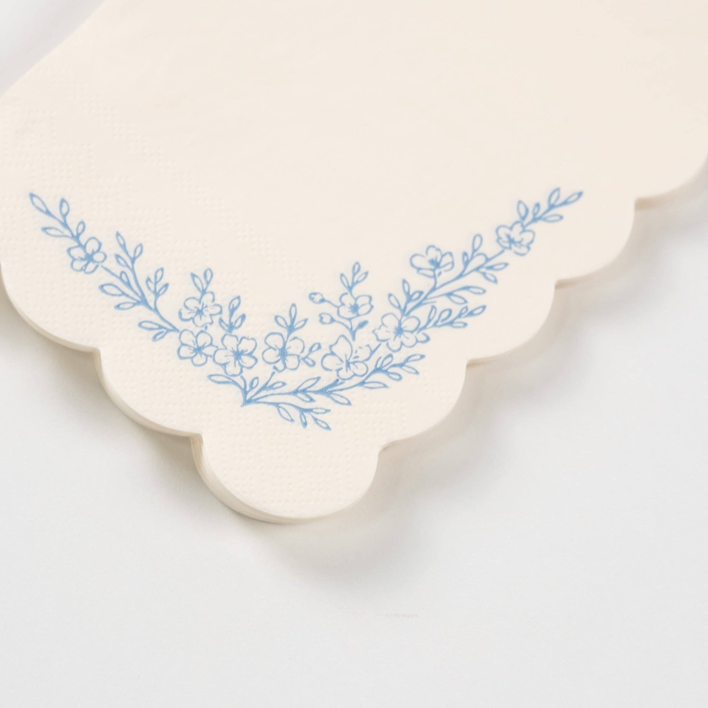 Close-up of dusty blue guest towel showing floral corner detail.
