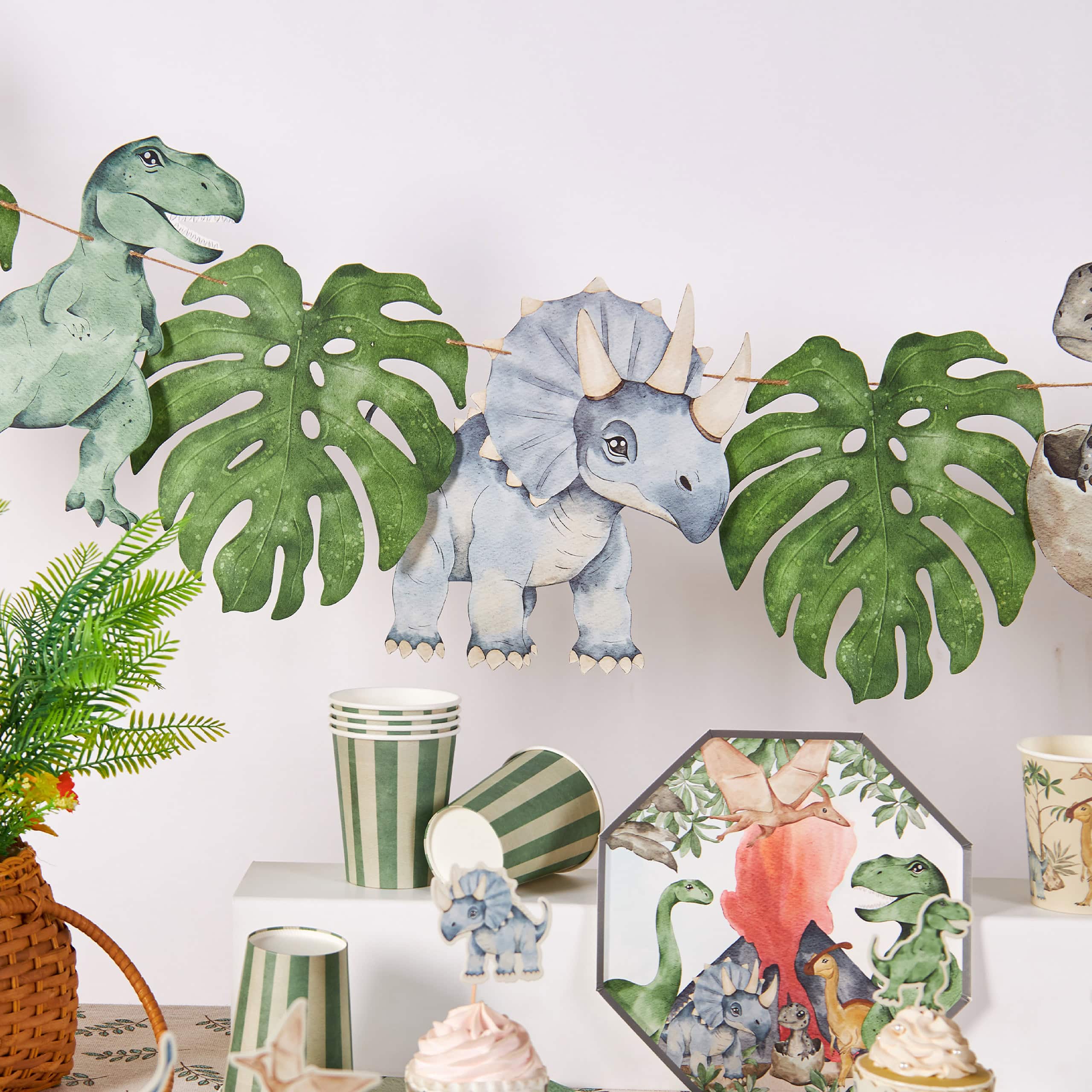 dinosaur birthday banner with leaves above matching decor