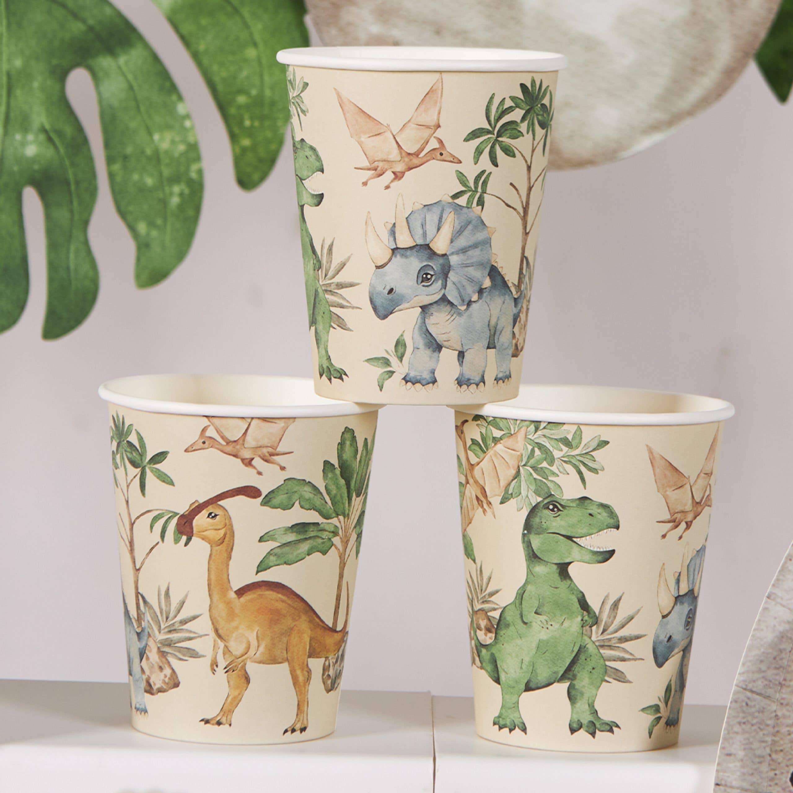 Three dinosaur cups showing assorted dinosaur characters
