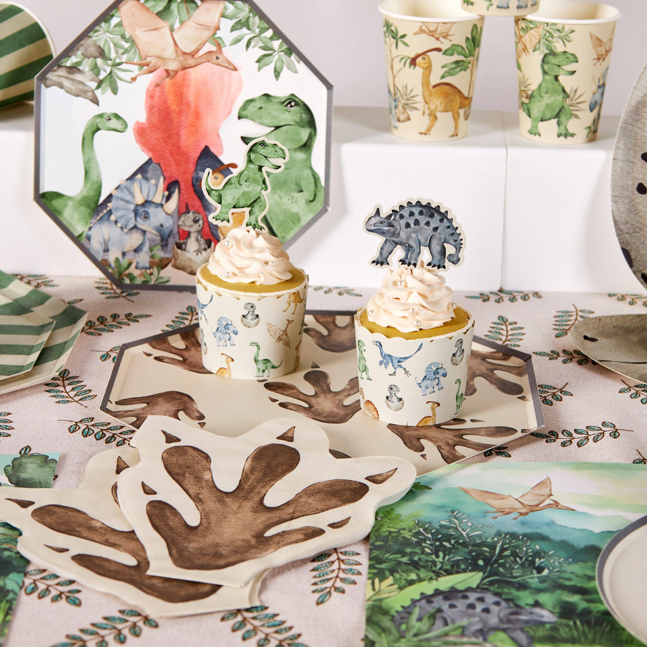 Dinosaur footprint napkins styled on party table with cupcake and decor
