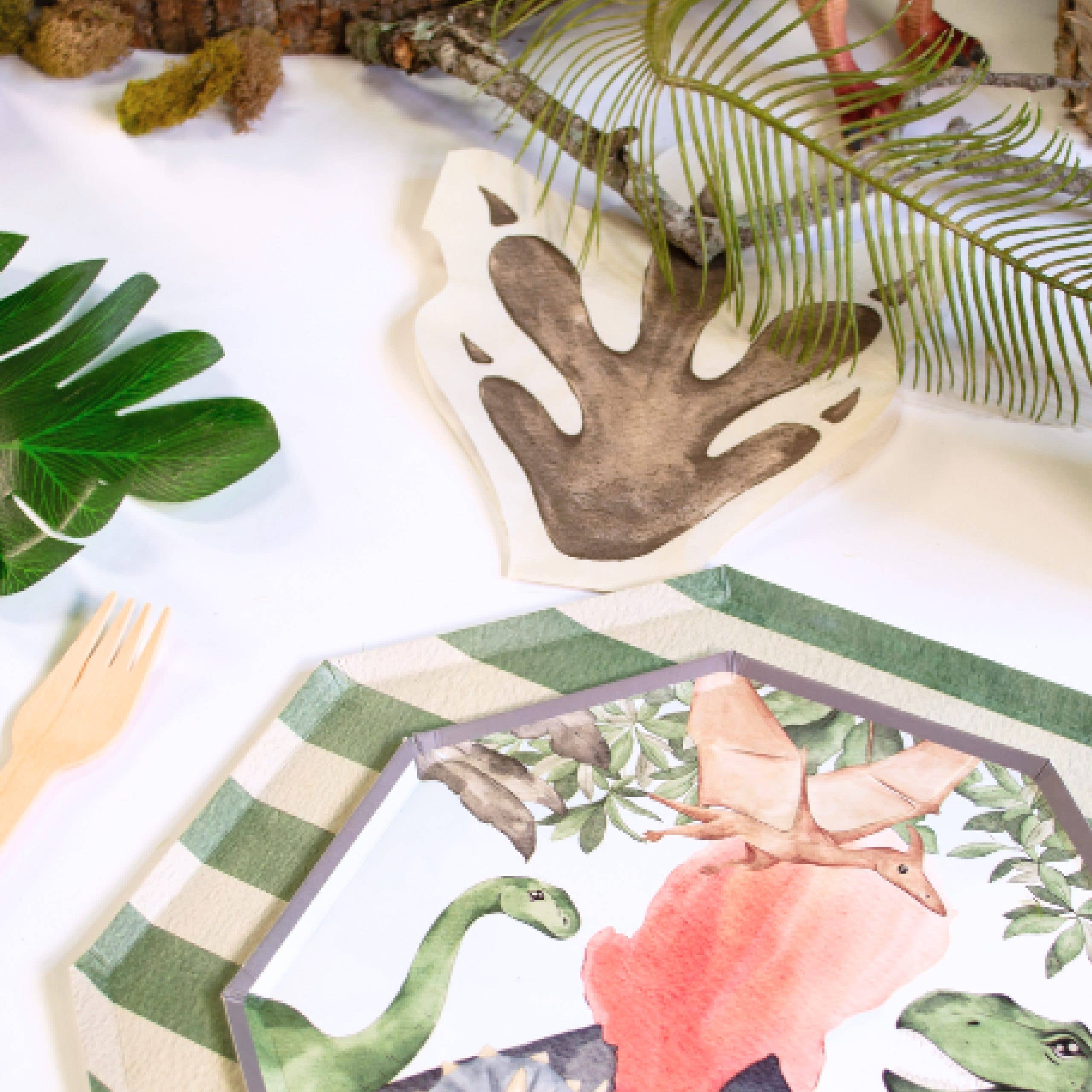 Dinosaur party table setup with footprint napkins and themed plates
