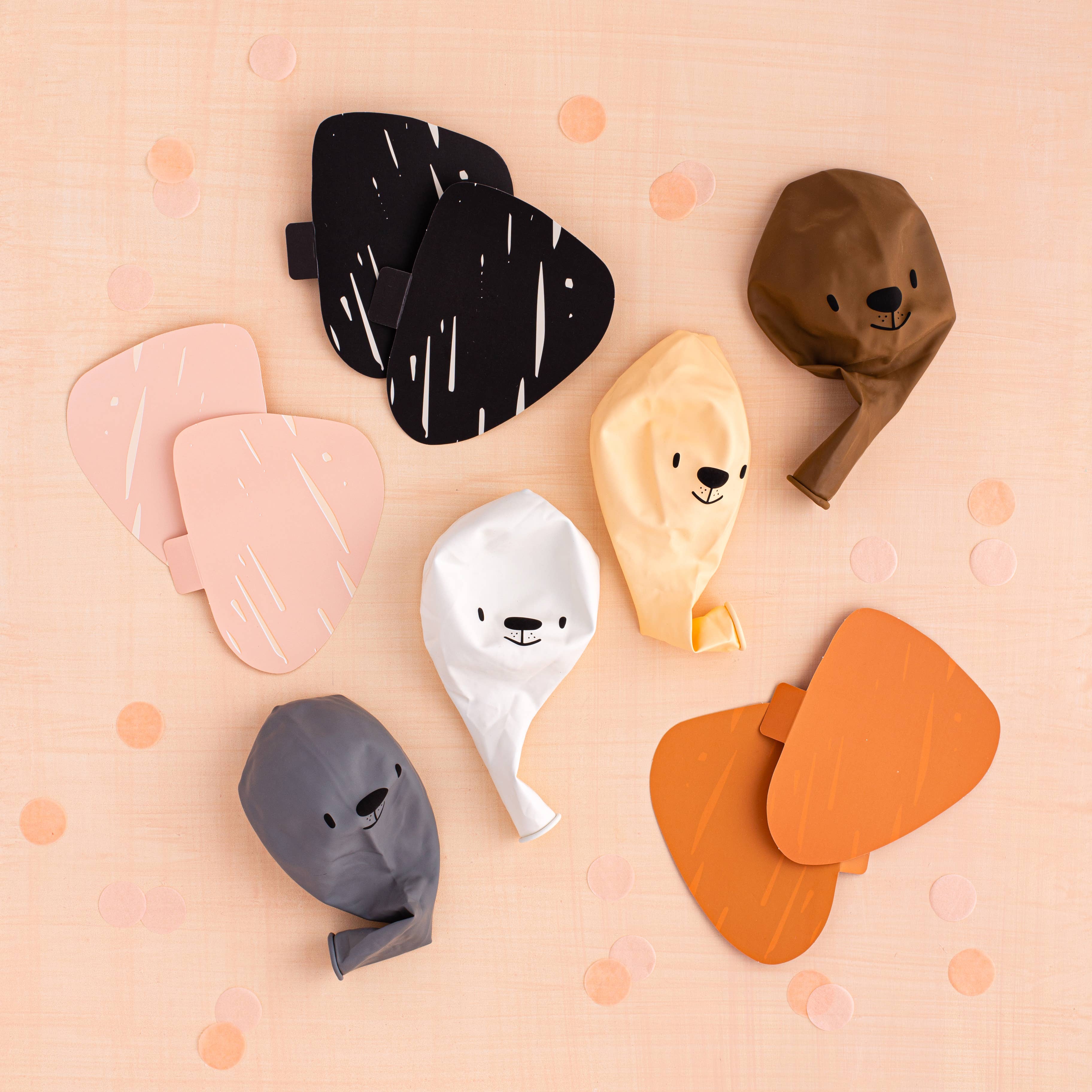 Flat lay of balloon kit components including balloons, paper ears, and accessories