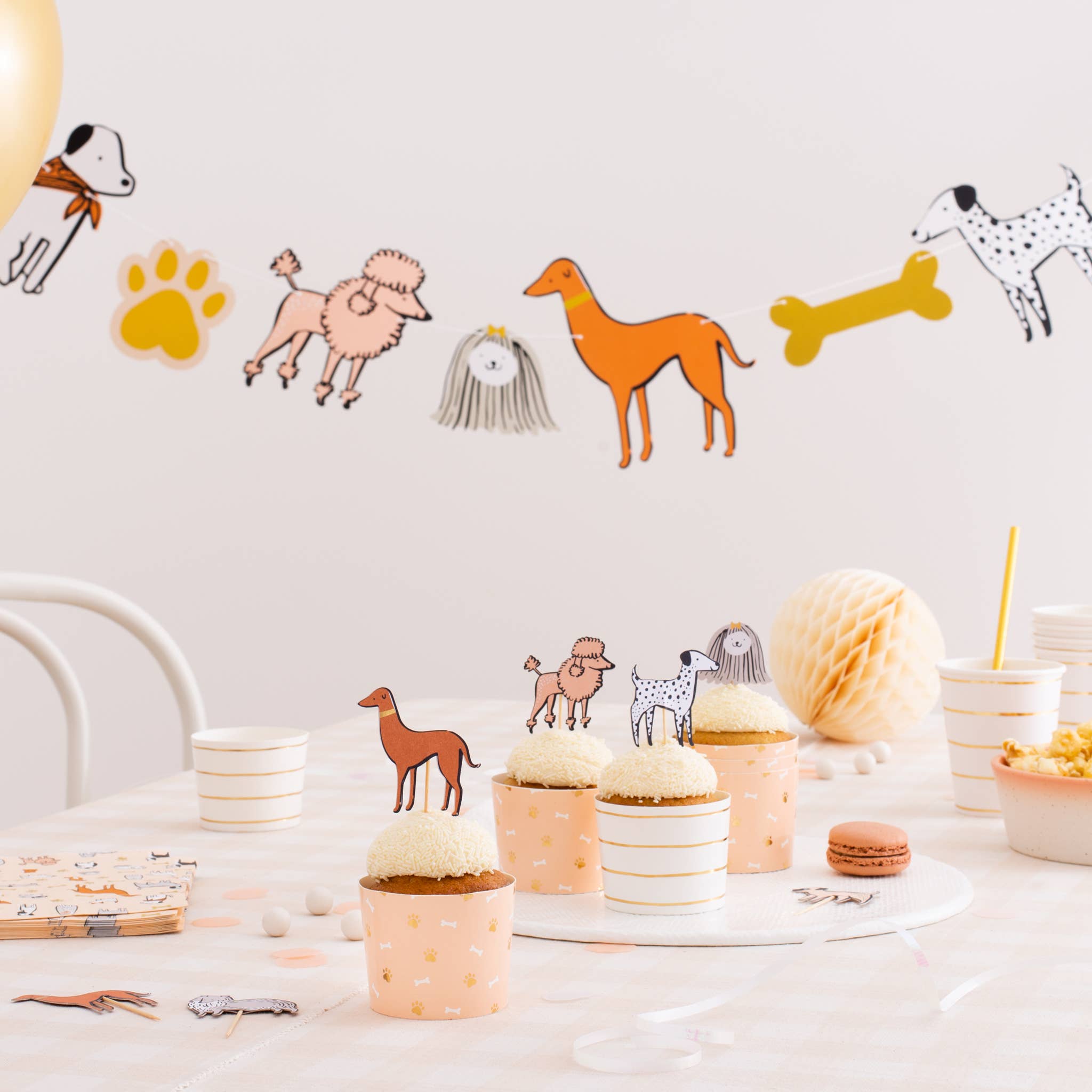 Dog birthday party setup featuring Bow Wow Thingamajigs banner and balloon decorations