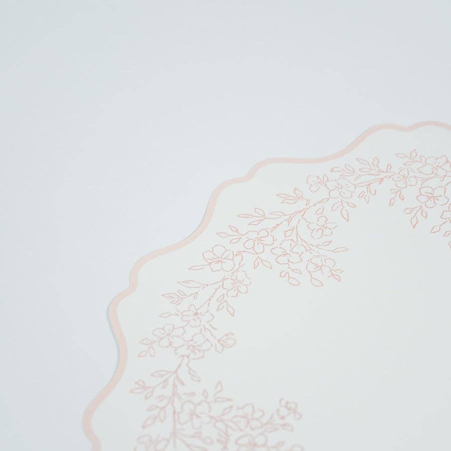 Detailed view of the soft scalloped border and botanical sprig pattern