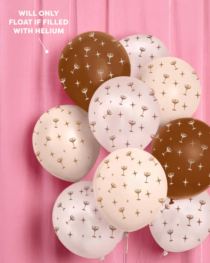 Large cluster of espresso martini print balloons in brown, blush, and cream against a pink velvet backdrop, with a callout noting balloons will only float when filled with helium