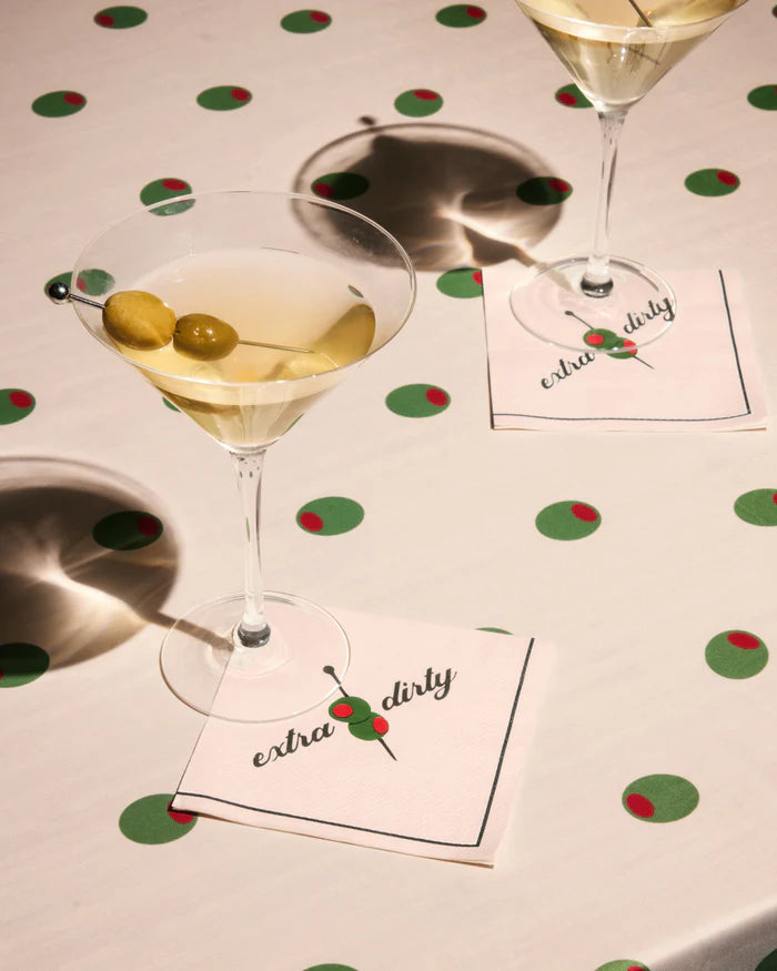 Extra dirty cocktail napkins styled with dirty martini glasses on an olive print tablecloth