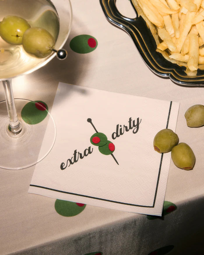 Extra dirty martini cocktail napkin styled with a dirty martini and french fries on an olive print tablecloth