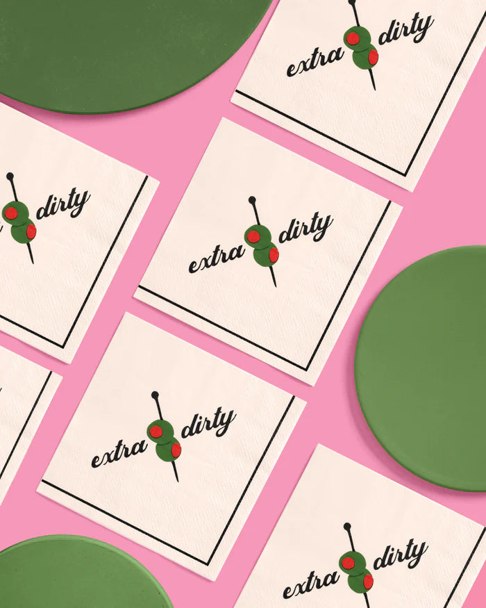 Extra dirty martini cocktail napkins arranged in a grid pattern with green plates on a pink background