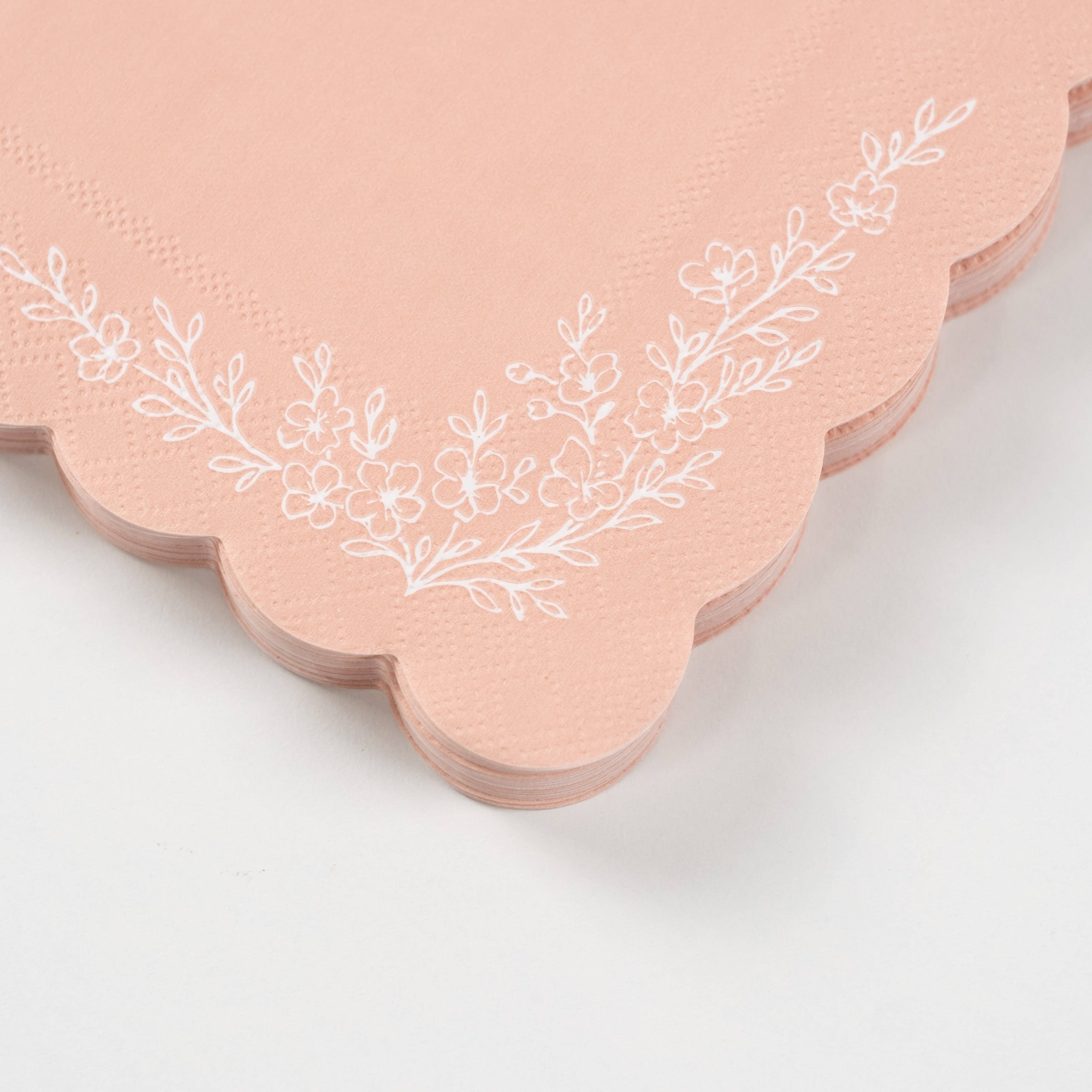 Close-up of scalloped edge and floral detail on pink napkin