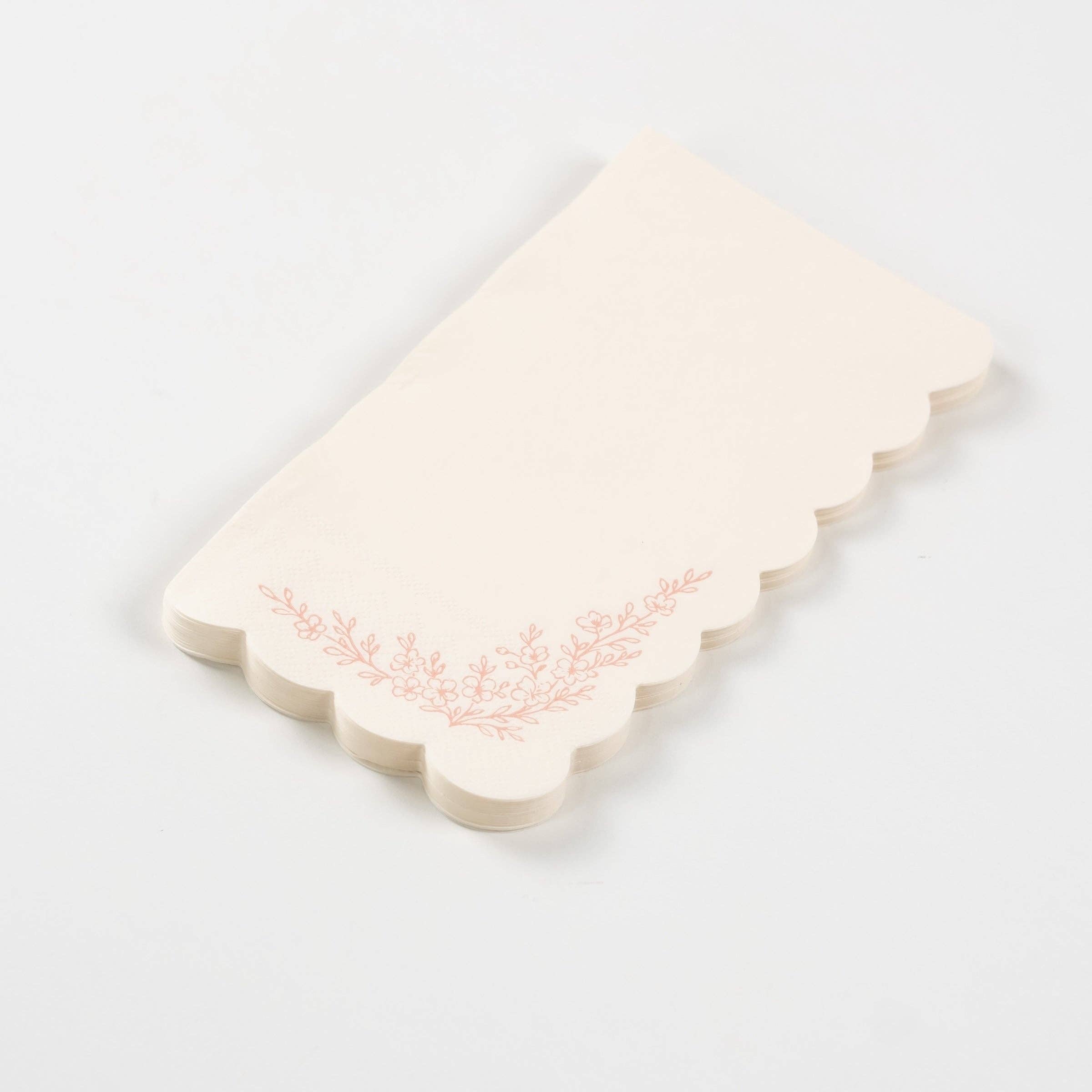 Fanned stack of pink scalloped guest towels on a white surface