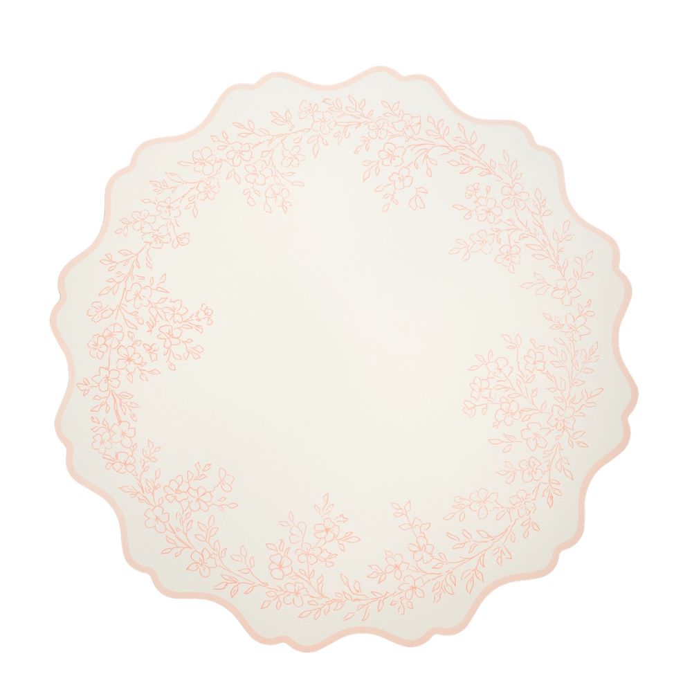 Single round blush pink placemat with a scalloped edge and floral border