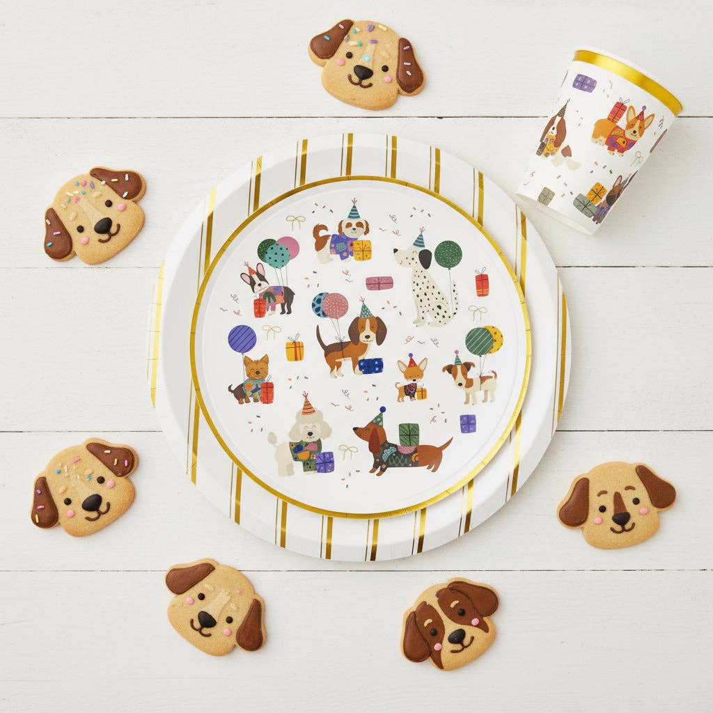gold striped plate layered with dog themed party plates and cookies
