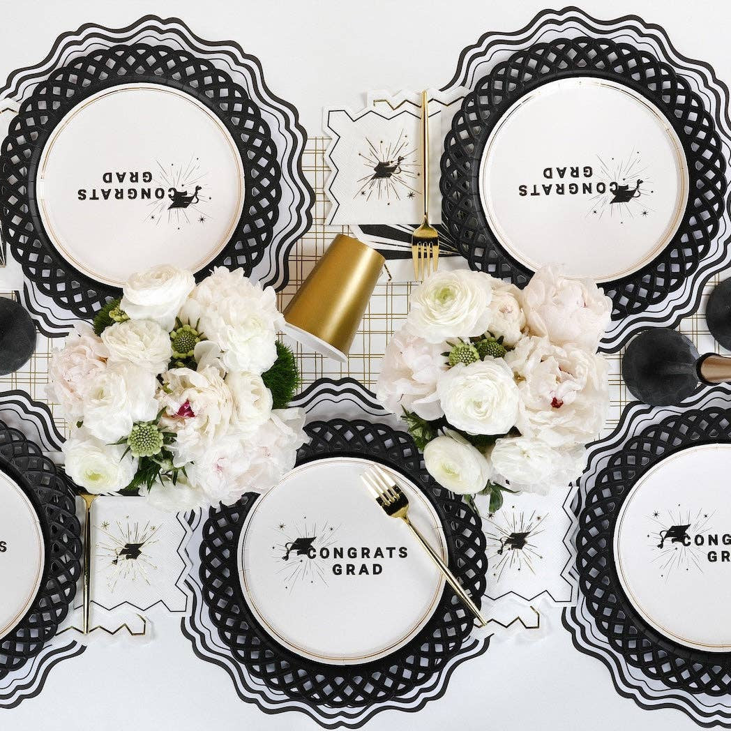 Overhead view of a sophisticated tablescape featuring grad cap napkins ready for a commencement toast.