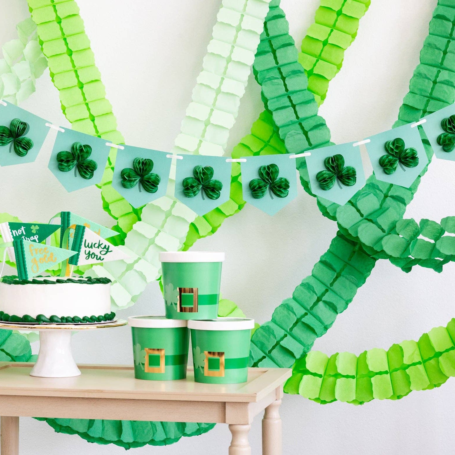 Green party backdrop featuring honeycomb shamrock banner and paper streamers