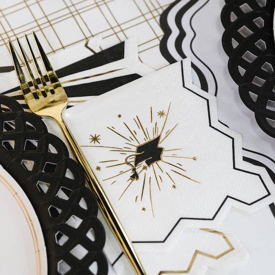 A grad cap napkin tucked beside a black lattice plate for a polished Ivy League Chic event.