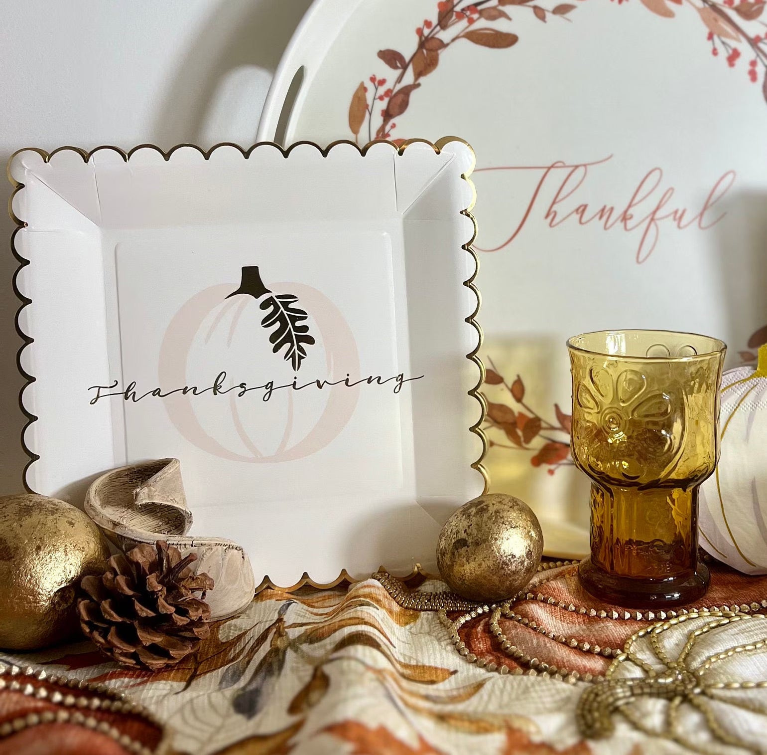 Thanksgiving paper plates featuring a gold foil edge and a pumpkin.