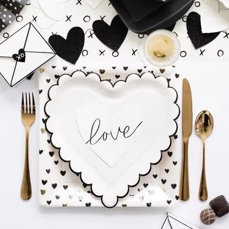 White paper cocktail napkins with small black hearts and scalloped edges - perfect for valentines day, galentines day or an anniversary party