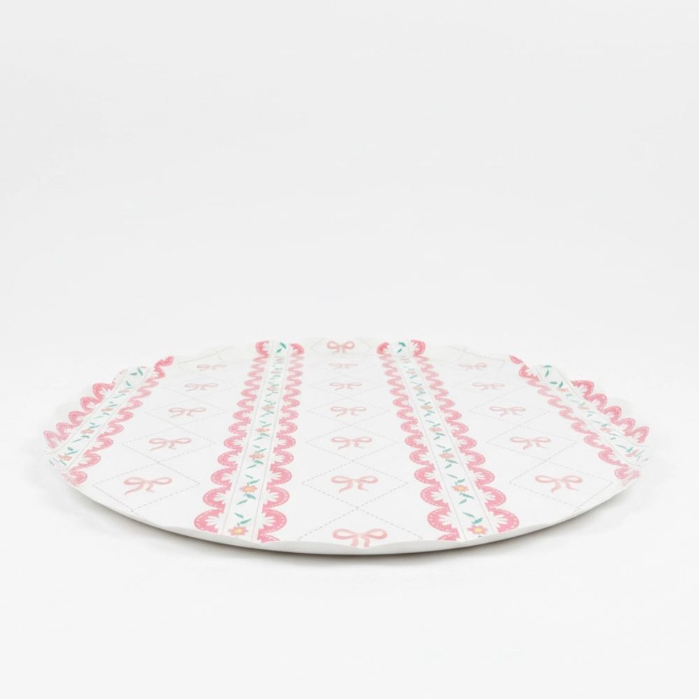 Side profile of a flat large paper plate with pink ribbon pattern