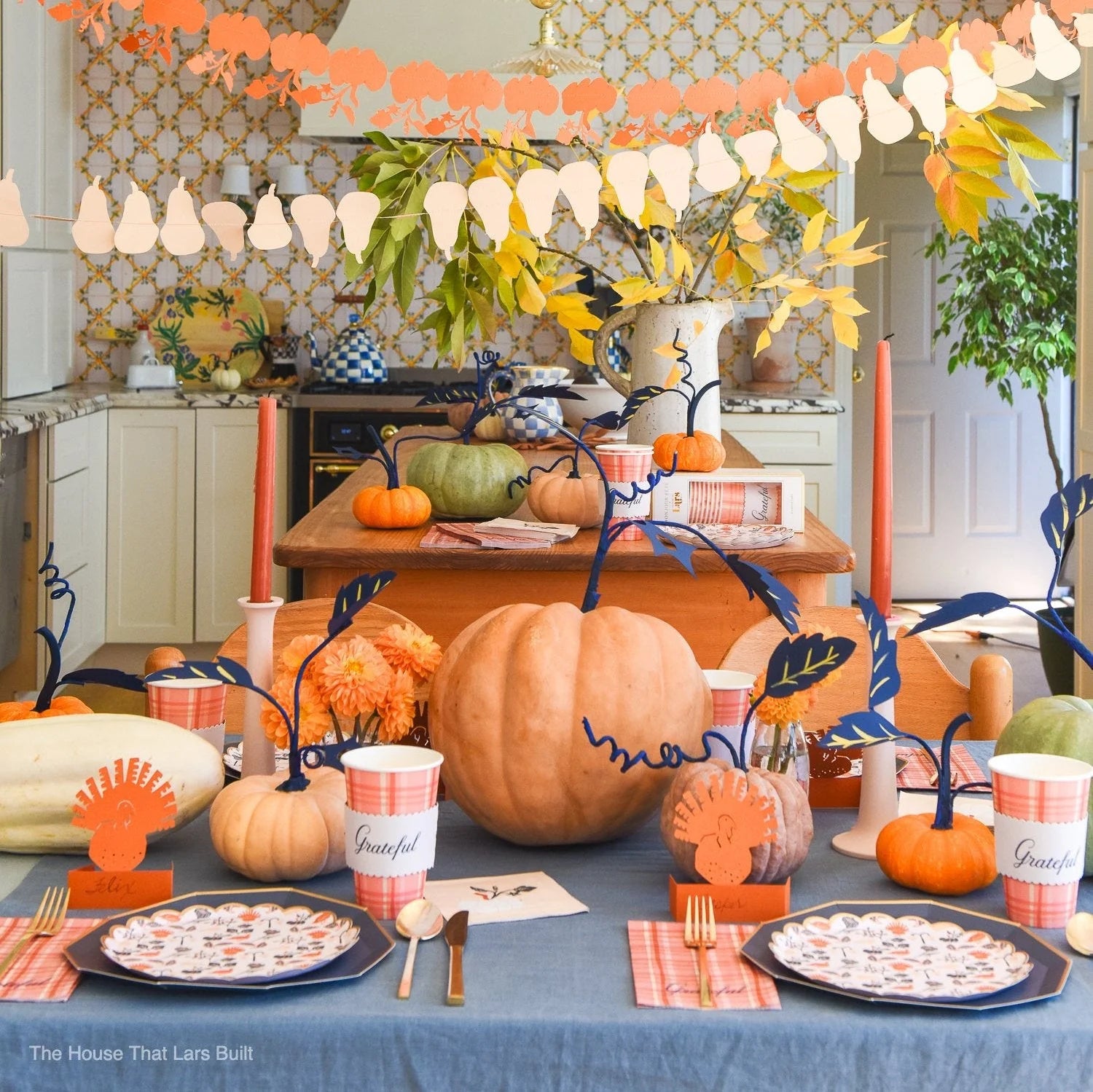 Thanksgiving kitchen tablescape featuring pumpkins and several plaid “Grateful” cups.