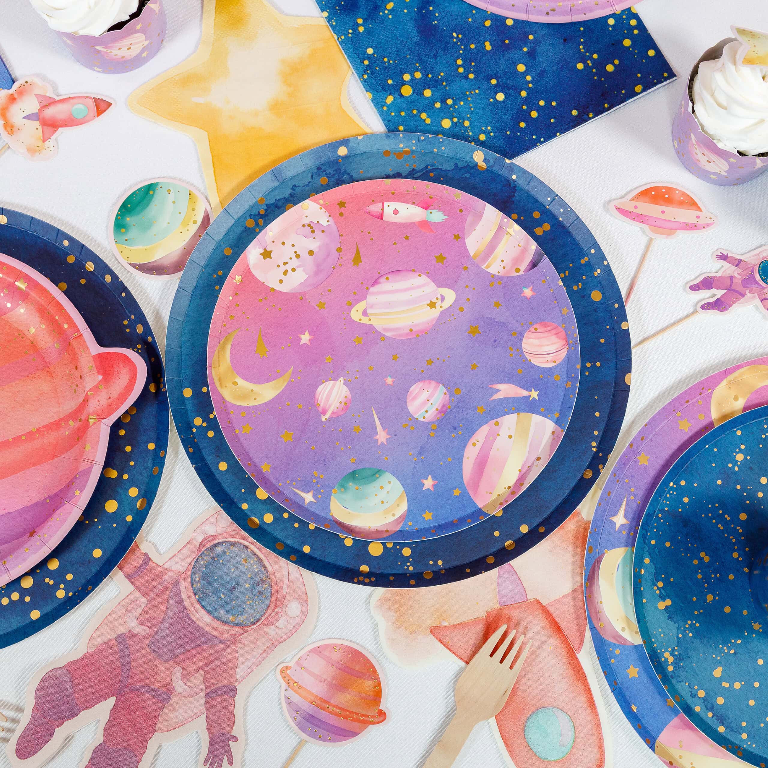layered galaxy plates with cupcake and astronaut party setup