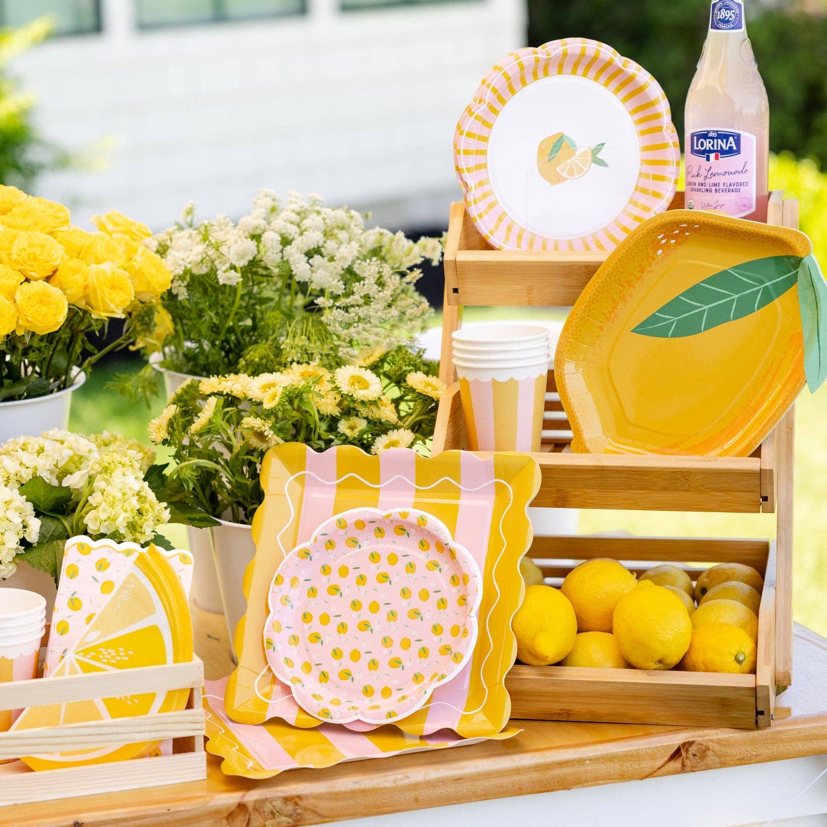 Lemon themed party table with plates, cups, and citrus decor