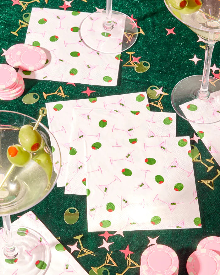 Martini and olive print cocktail napkins on green velvet table with dirty martinis and pink poker chips