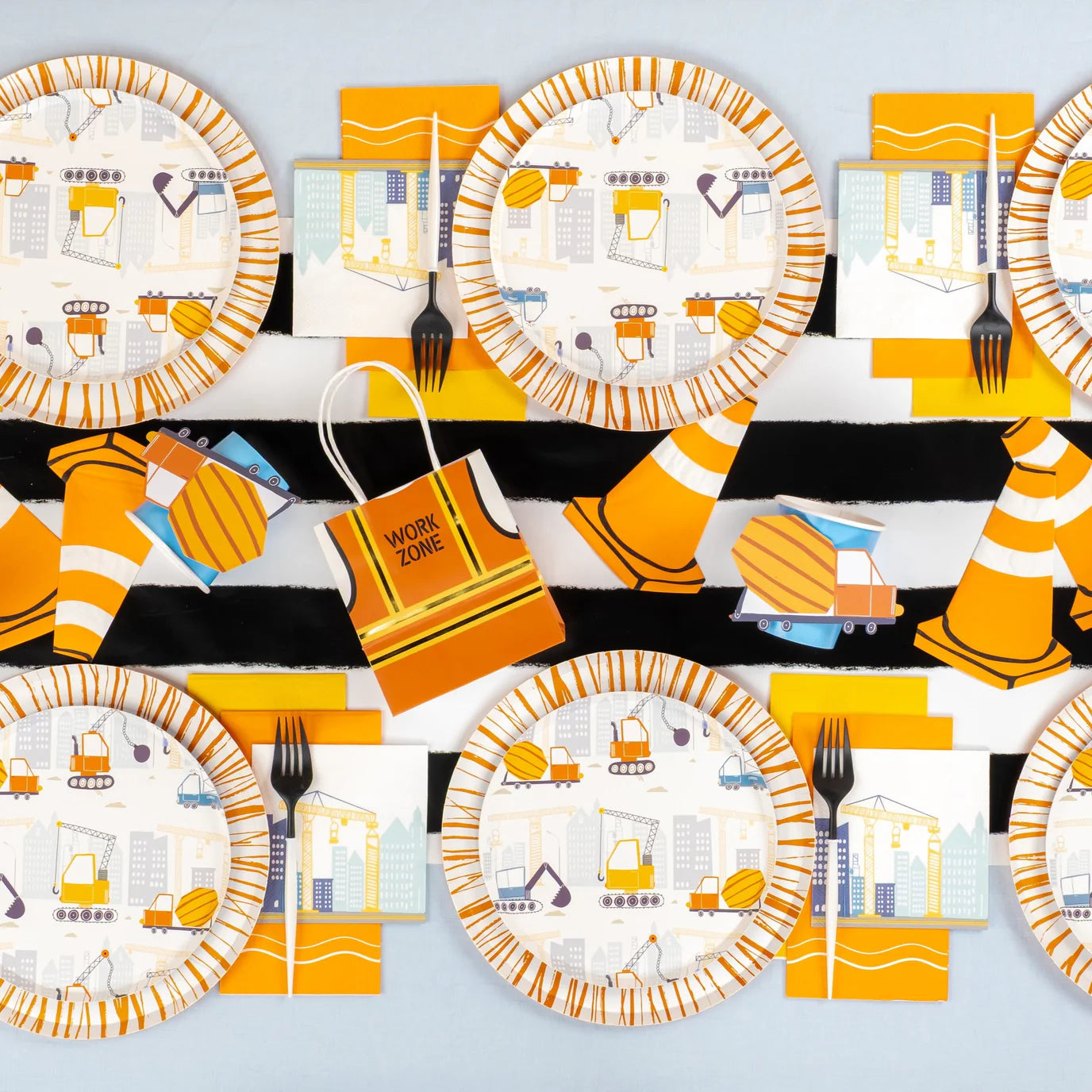 Overhead construction party table with cones, plates, and truck stickers used as accents.