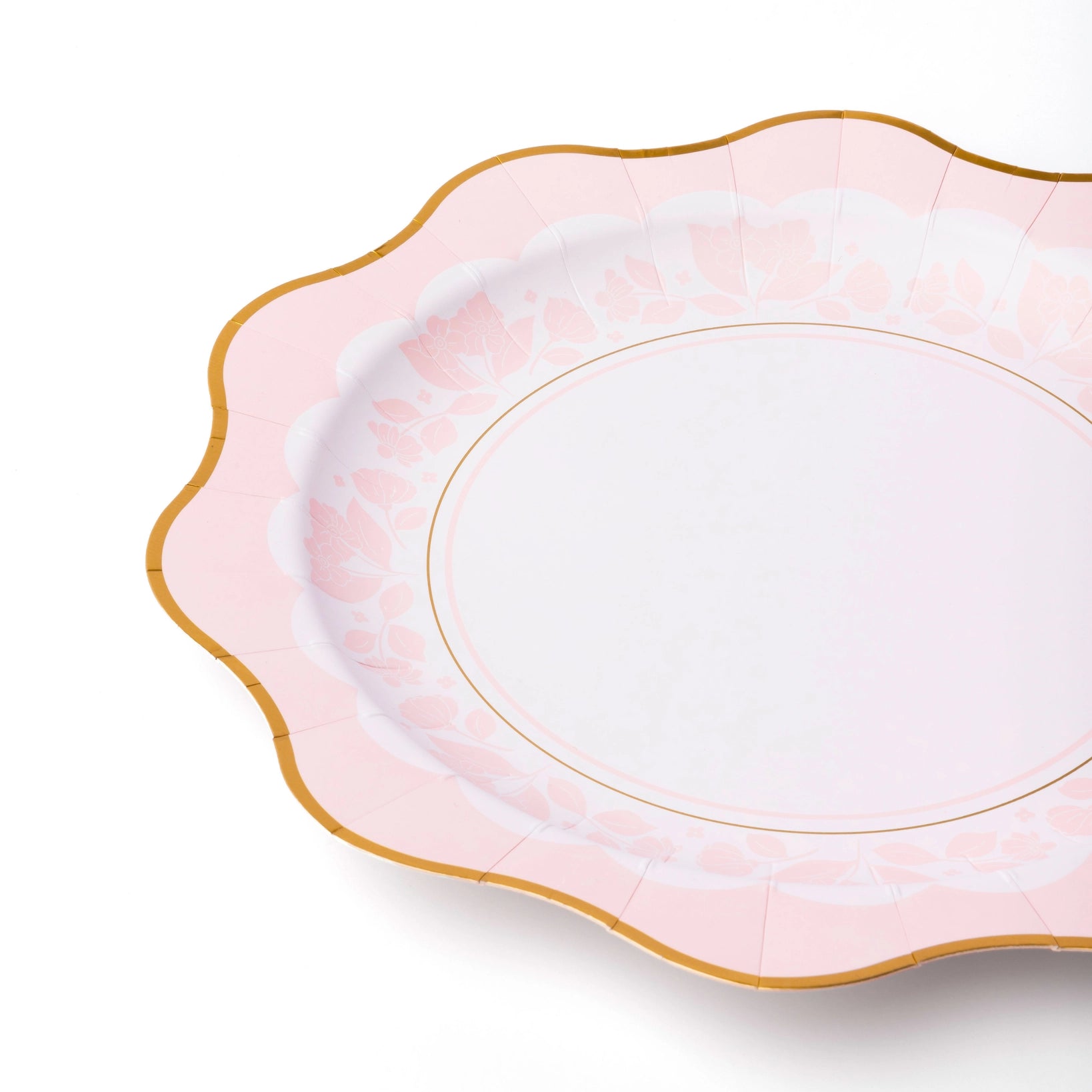Mixed tableau of pink and blue floral plates for gender‑reveal garden tea.