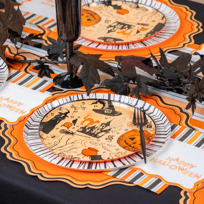 Tablescape with icon dinner plates and striped runner featuring Happy Halloween napkins.