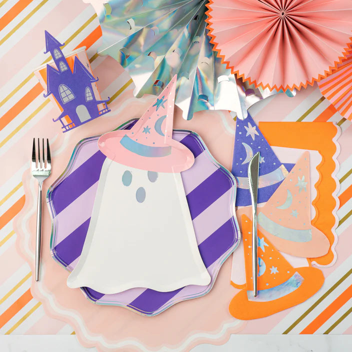 Pastel place setting with ghost plate and witch hat napkins beside the haunted house cup.
