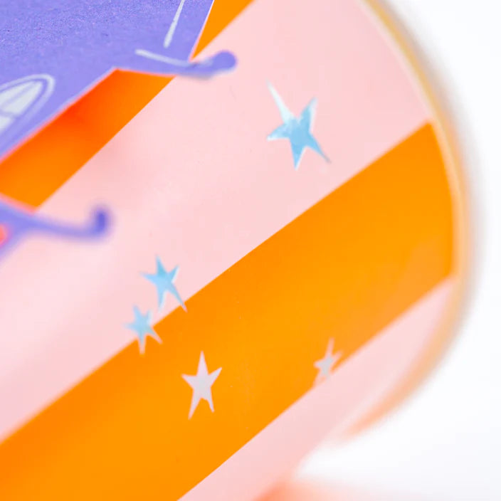 Macro of pink and orange striped Halloween cup with silver stars.