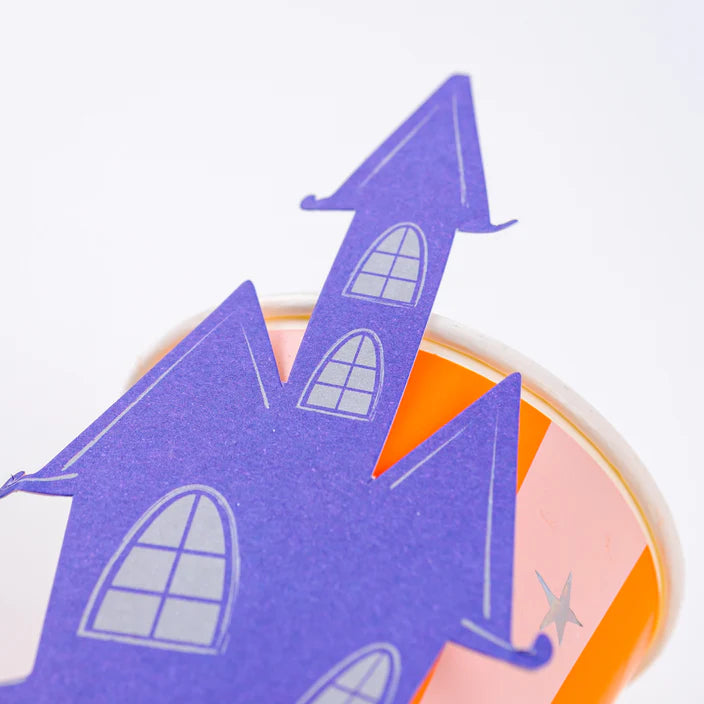 Close view of haunted house topper leaning on the pink and orange striped cup.