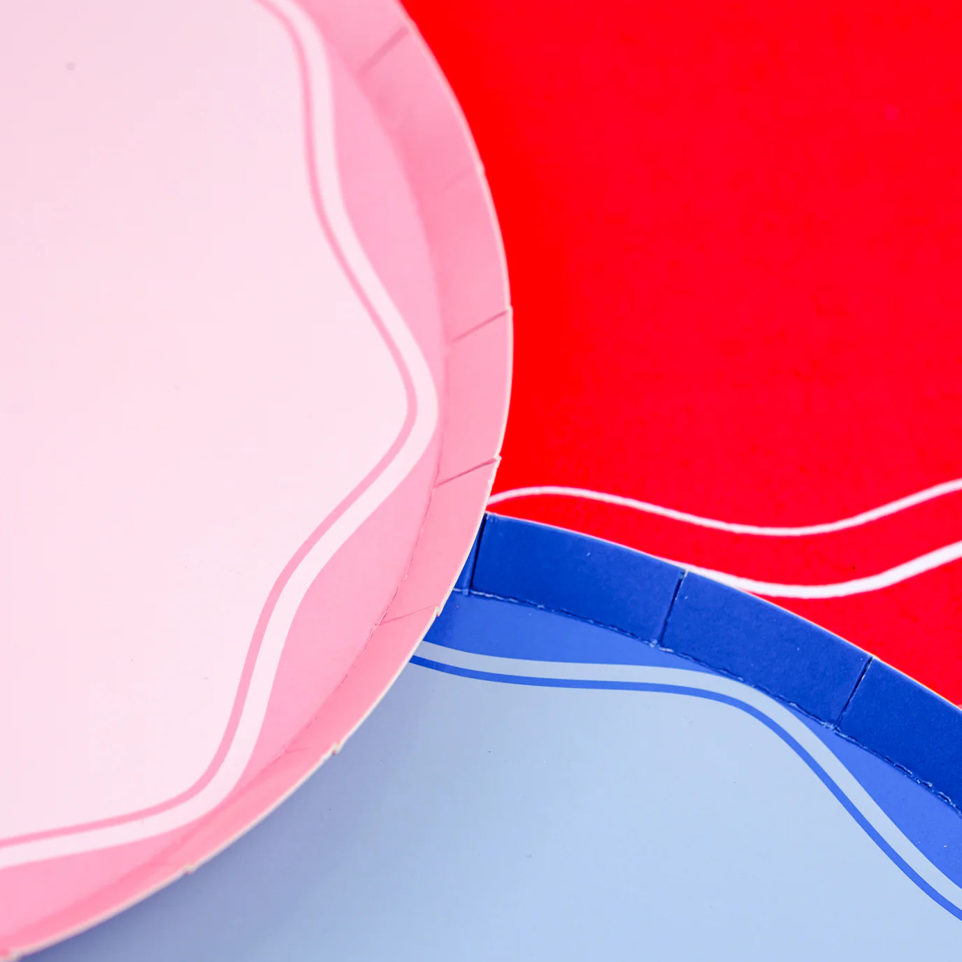 Detail of blush plate and blue plate against red background, curved border