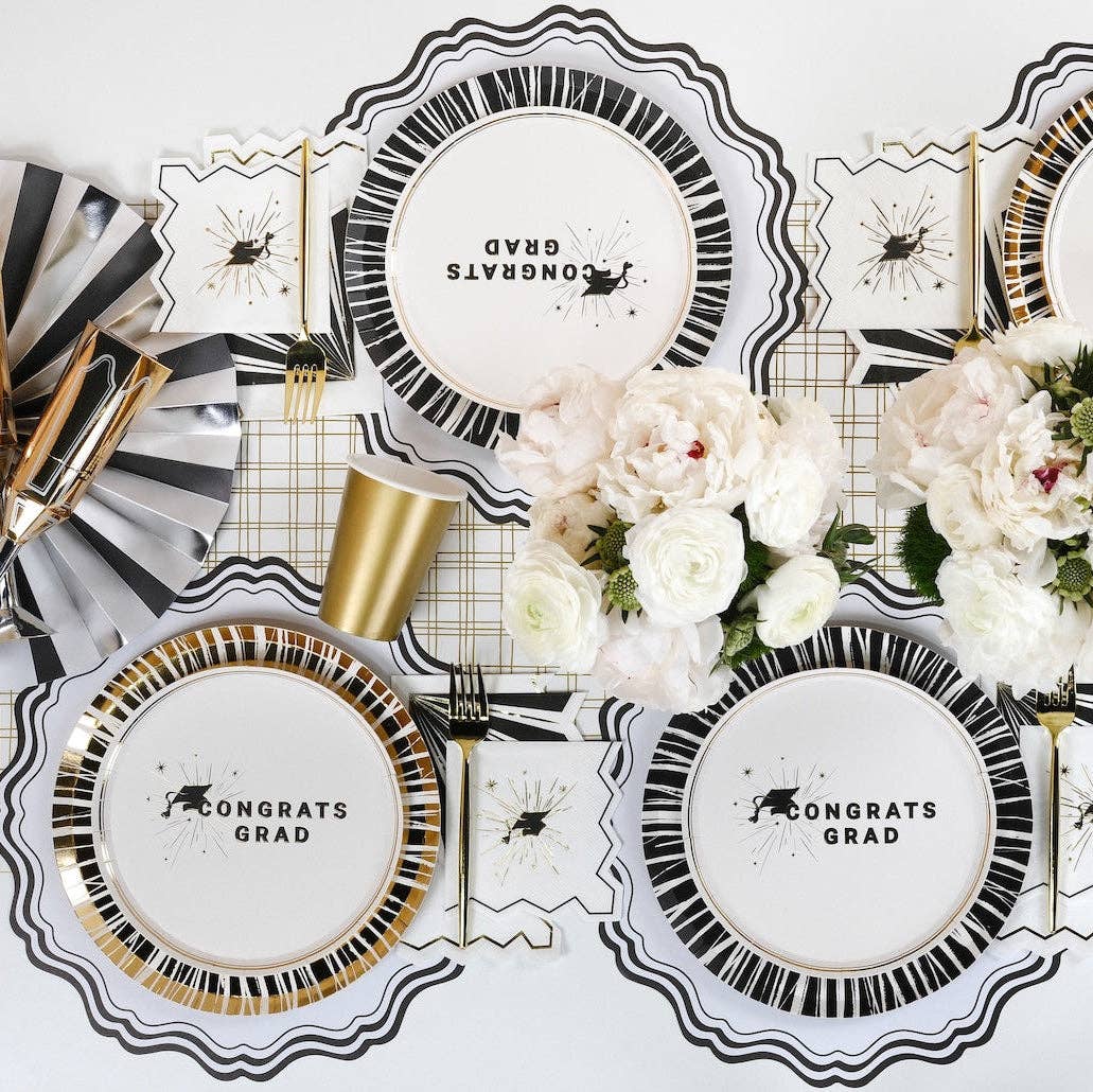 An upscale Moody Scholar commencement table display featuring graduation cocktail napkins and gold party accents.