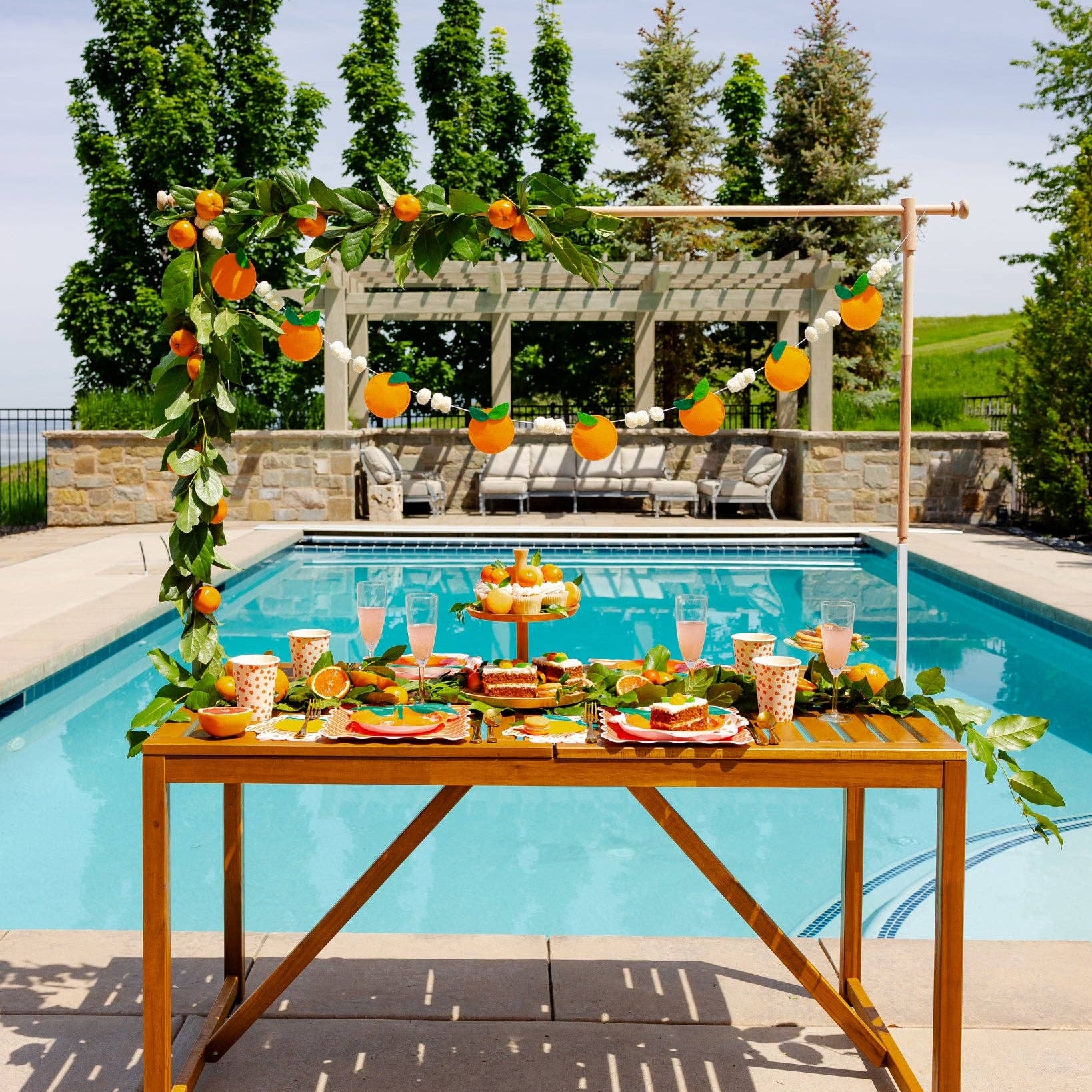 Orange felt banner hanging above a citrus-themed pool party table.