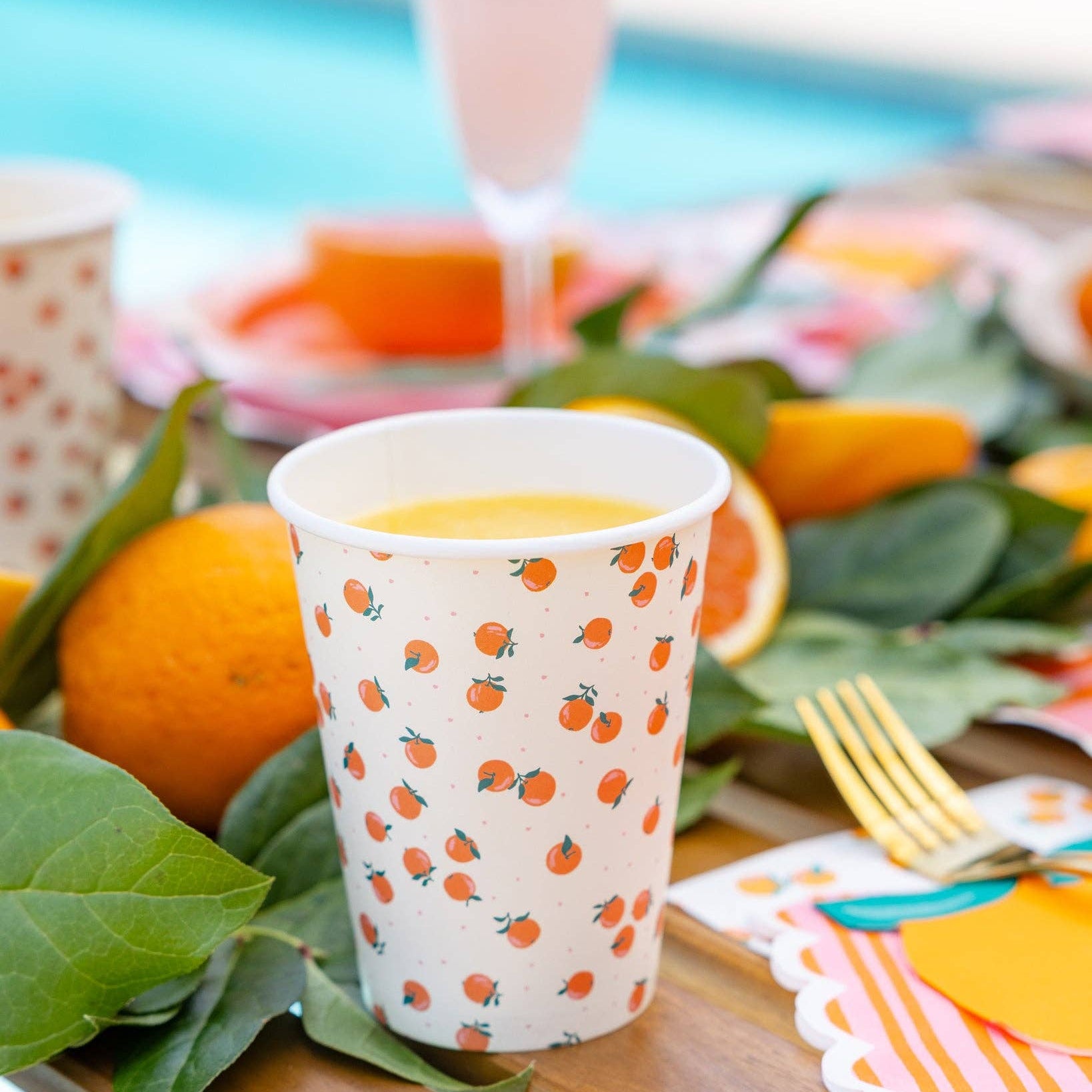 Orange themed party cup styled on a citrus summer party table.