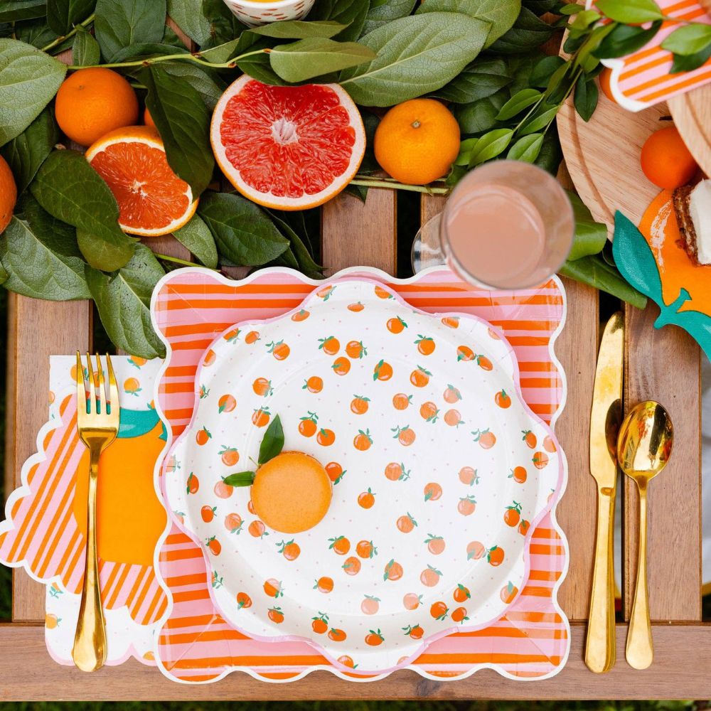 Orange and pink striped paper plate with scalloped edges.
