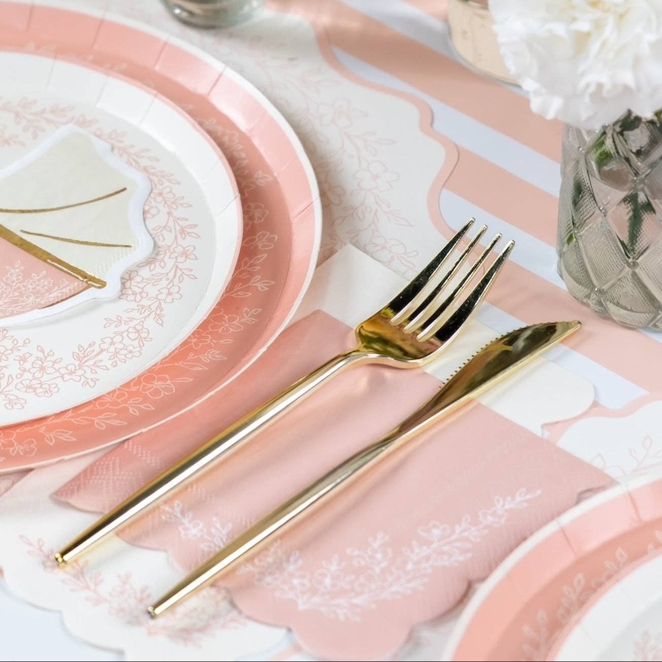 Pink guest towel paired with a pink lace plate and gold fork
