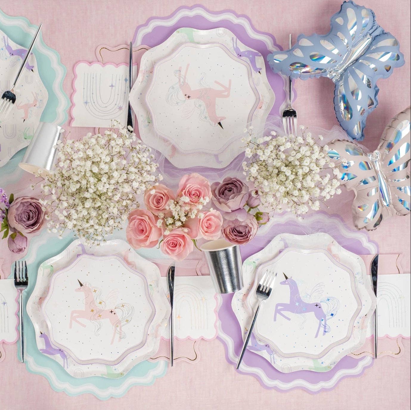 pastel unicorn party table with lavender placemats, flowers, and plates