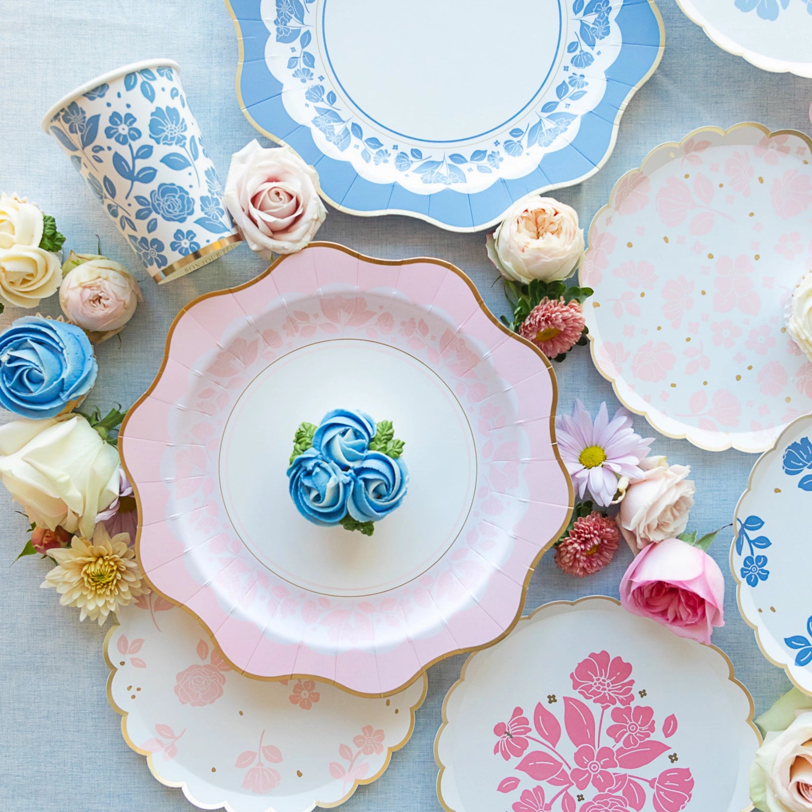 Flatlay of Petal Pink floral dessert plates styled with cupcakes and roses—elegant pink floral plates.