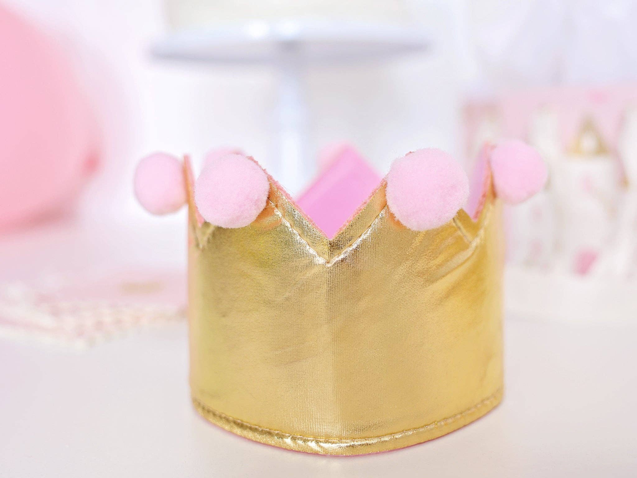 Close-up of the Gold Foil Tiara material and pink pom-pom trim on the Girl Birthday Headpiece.