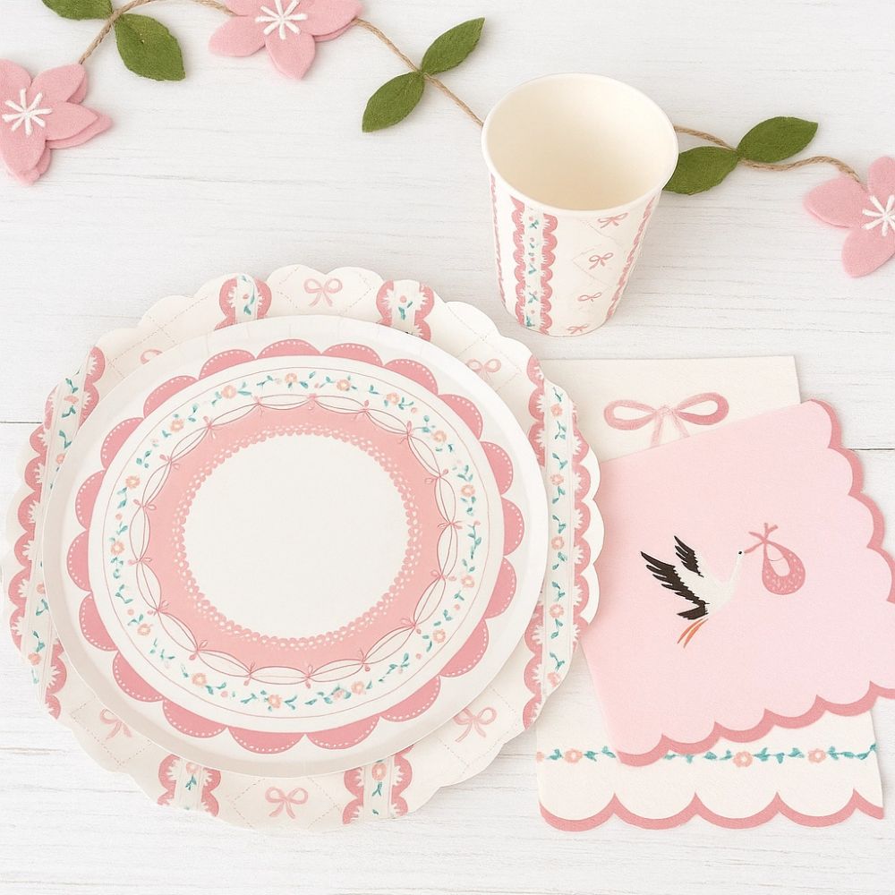 Pink coquette plate styled with a stork baby shower napkin and pink garland