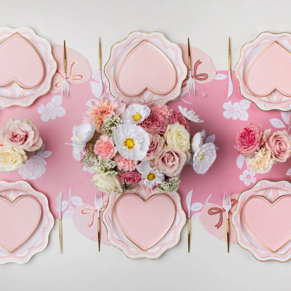 Pink bow dinner plates styled with heart plates and floral centerpiece