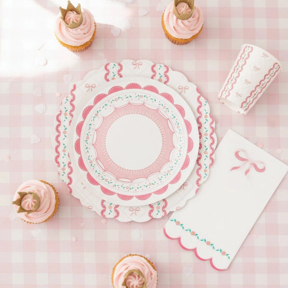 Overhead view of a bow napkin, stacked plates, and crown cupcakes