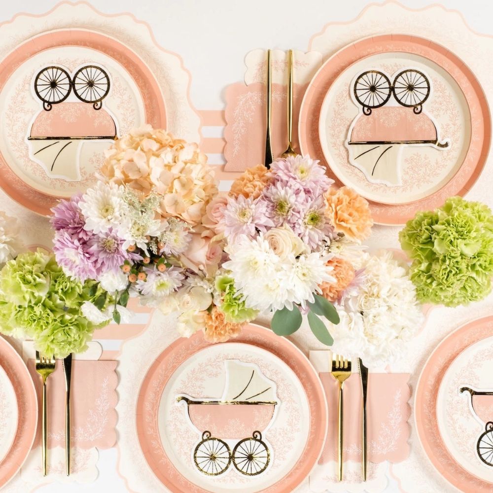Top view of pink floral plates with pastel decor for baby shower